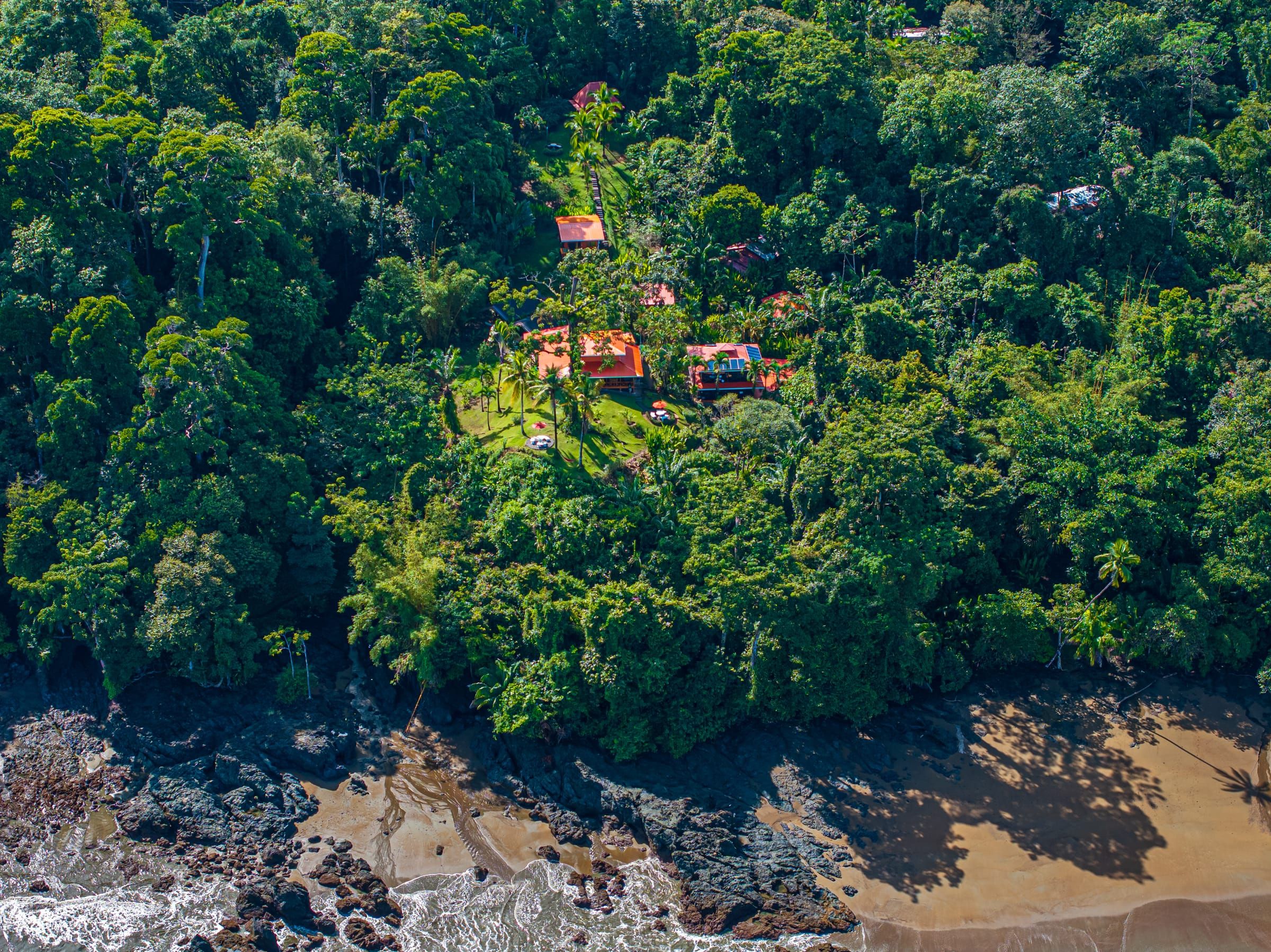Aerial view of the lodge's red roofs surrounded by jungle