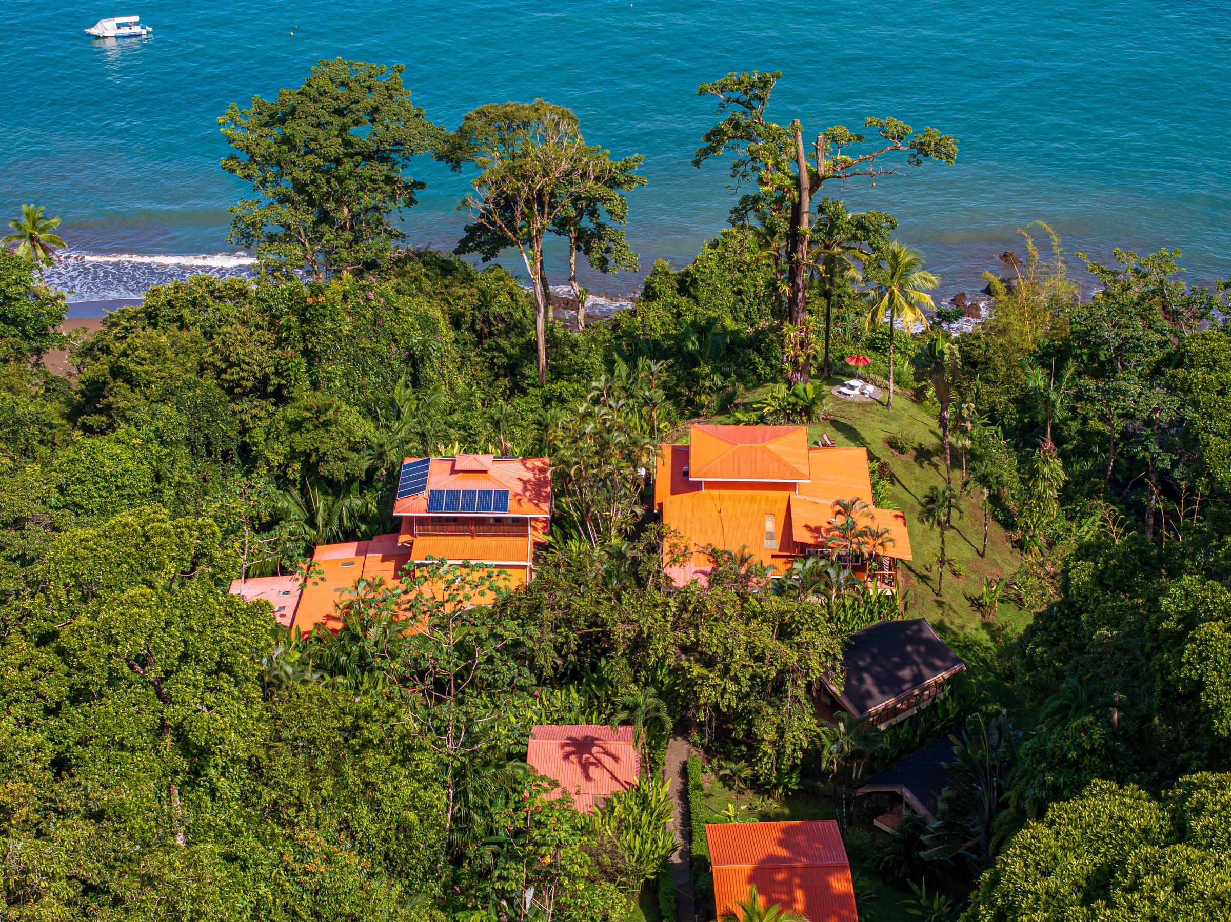 Aerial view of the lodge's roofs and solar panels above the Pacific