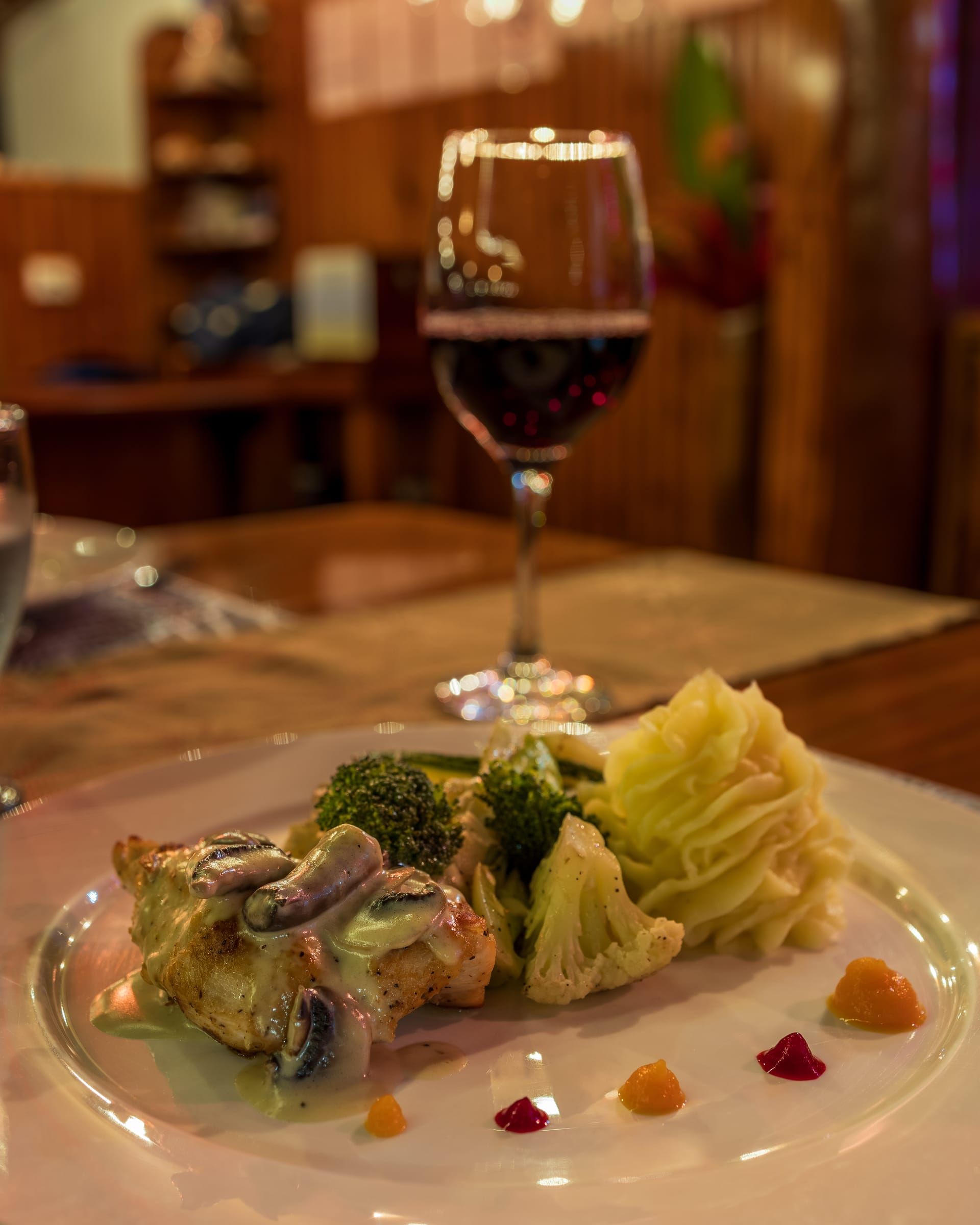 A vegetable dish with a glass of red wine at dinner